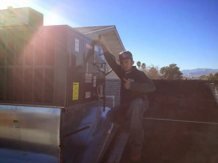 HVAC technician performing AC Tune-Up on a rooftop unit in High Point